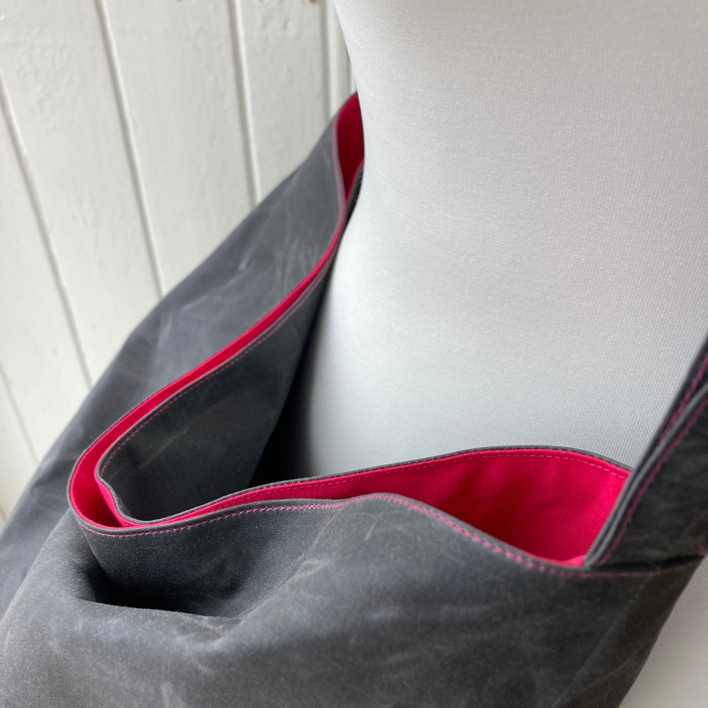 large grey oilskin bucket bag with shocking pink lining