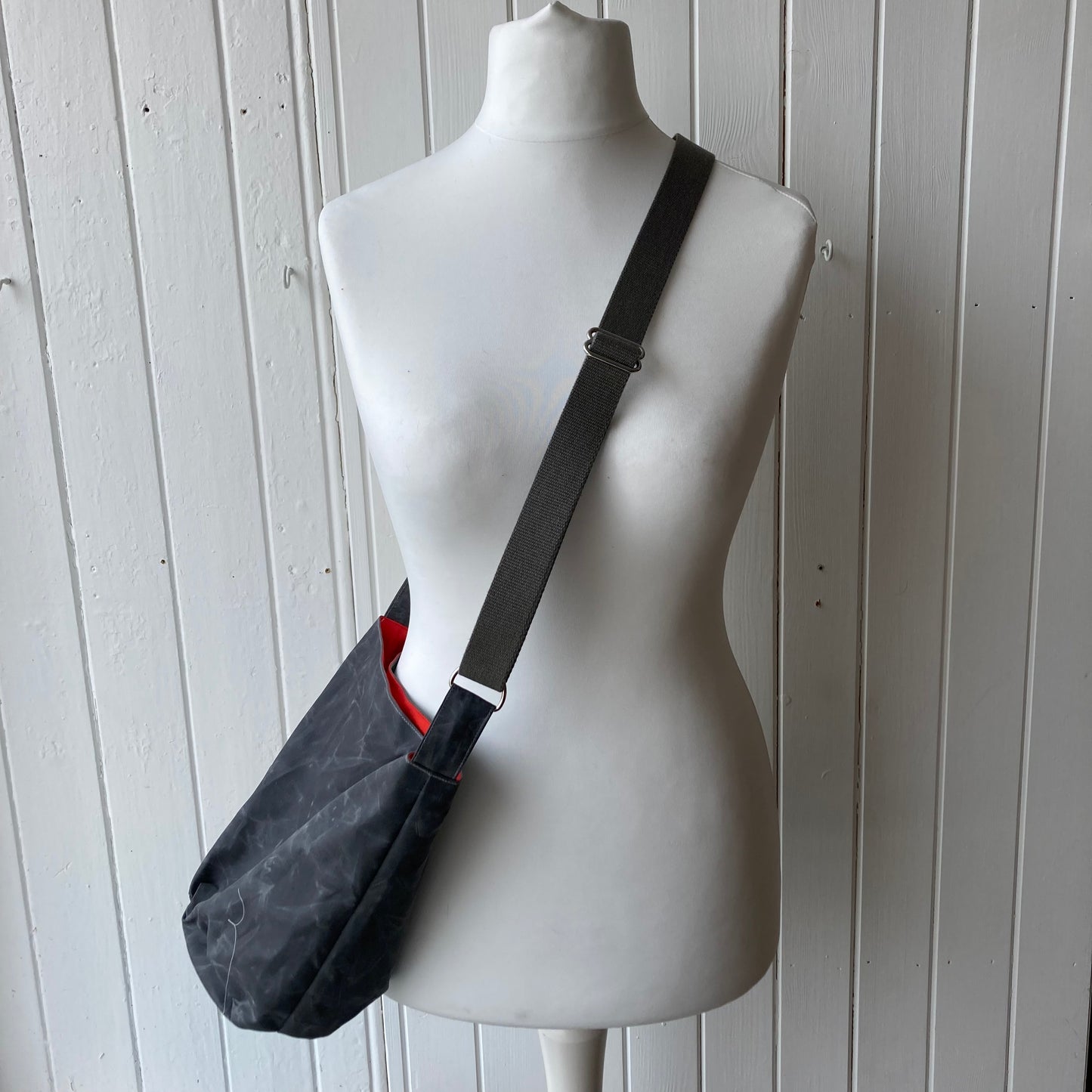 small grey oilskin bucket bag with dark orange/red lining