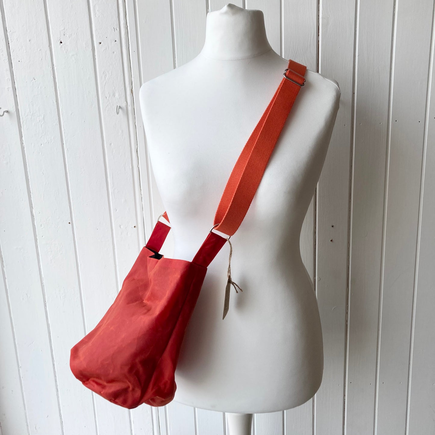 small dark orange oilskin bucket bag with pale pink lining