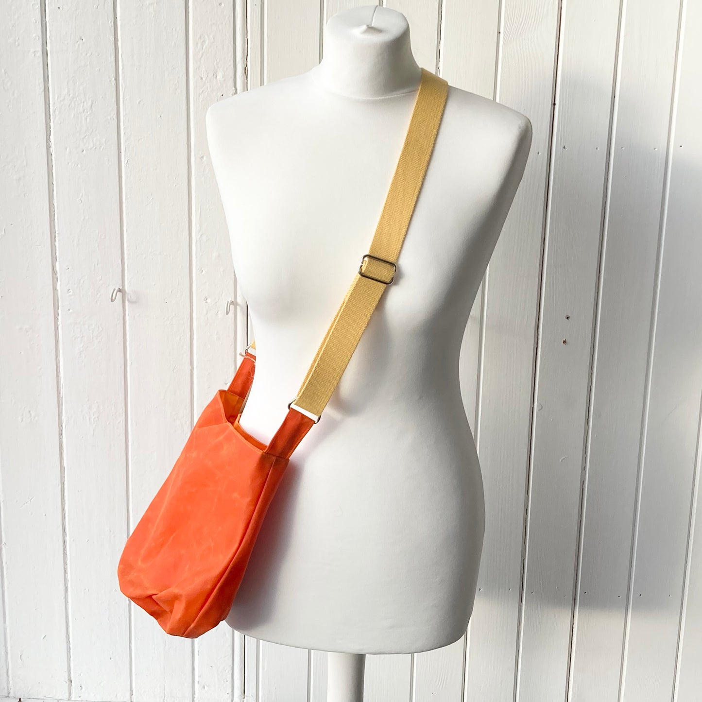 small orange with orange lining oilskin bucket bag