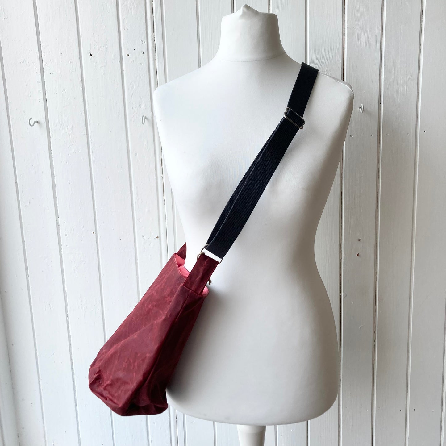 small dark red oilskin bucket bag with pale pink lining